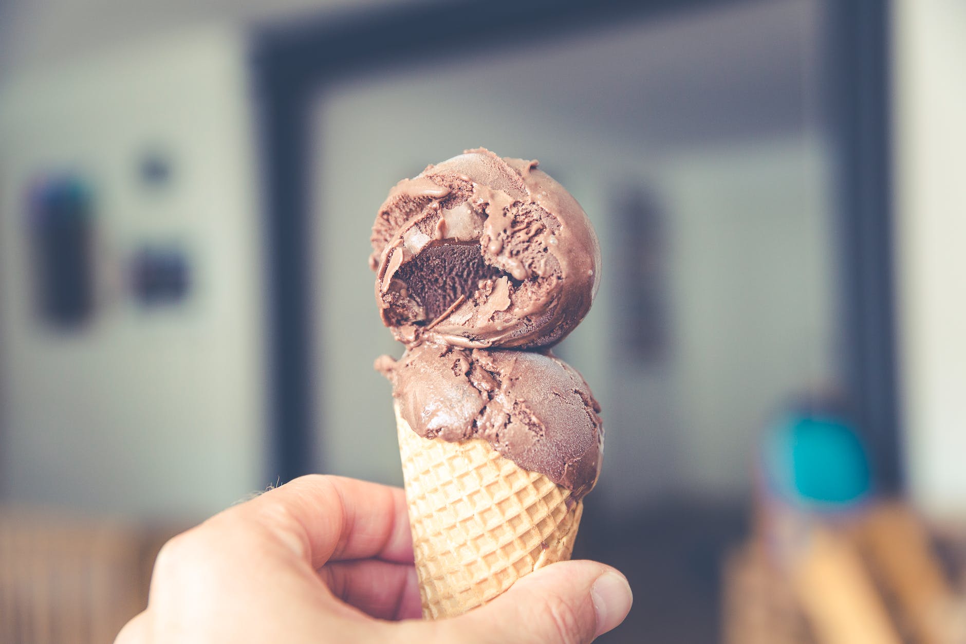person holding chocolate ice cream cone